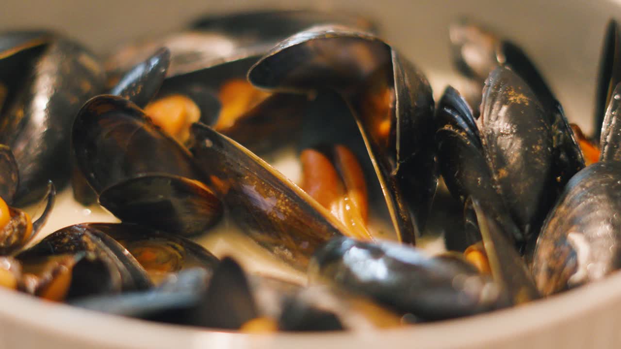 Bowl of Delicious Seafood Mussels in Bowl wth Steaming Hot White Wine Sauce. Tasty Fresh Mollusk Shellfish from Sea Ready to be Eaten