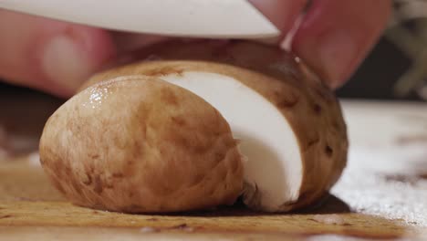 el chef está cortando setas de portobello marrones.