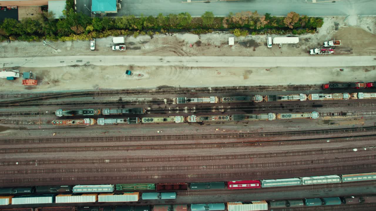 Top down aerial view of expansive railway systems, showcasing cargo and commuter trains, intricate track layouts, modern infrastructure, enhanced safety measures