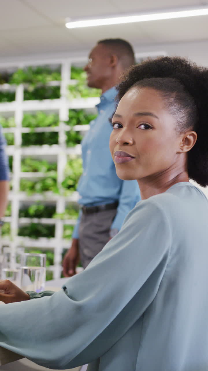 Vertical video of portrait of happy african american businesswoman smiling at office
