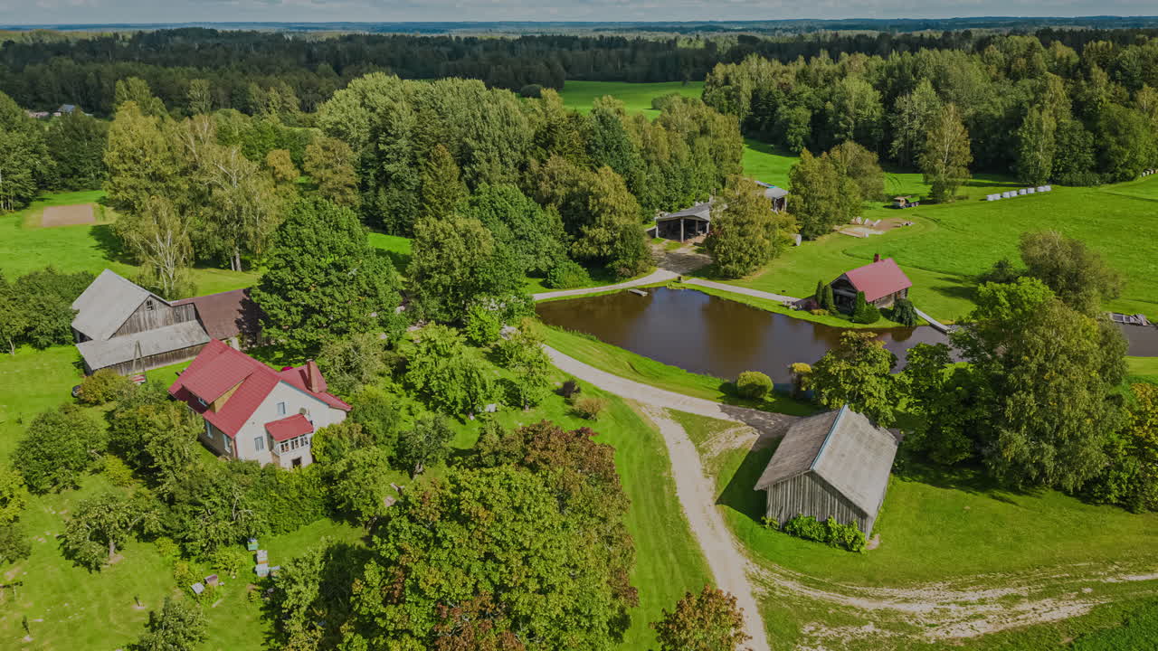 Ympyräliike: Aikaviivedronekuva lammesta ja järvenrantatalosta