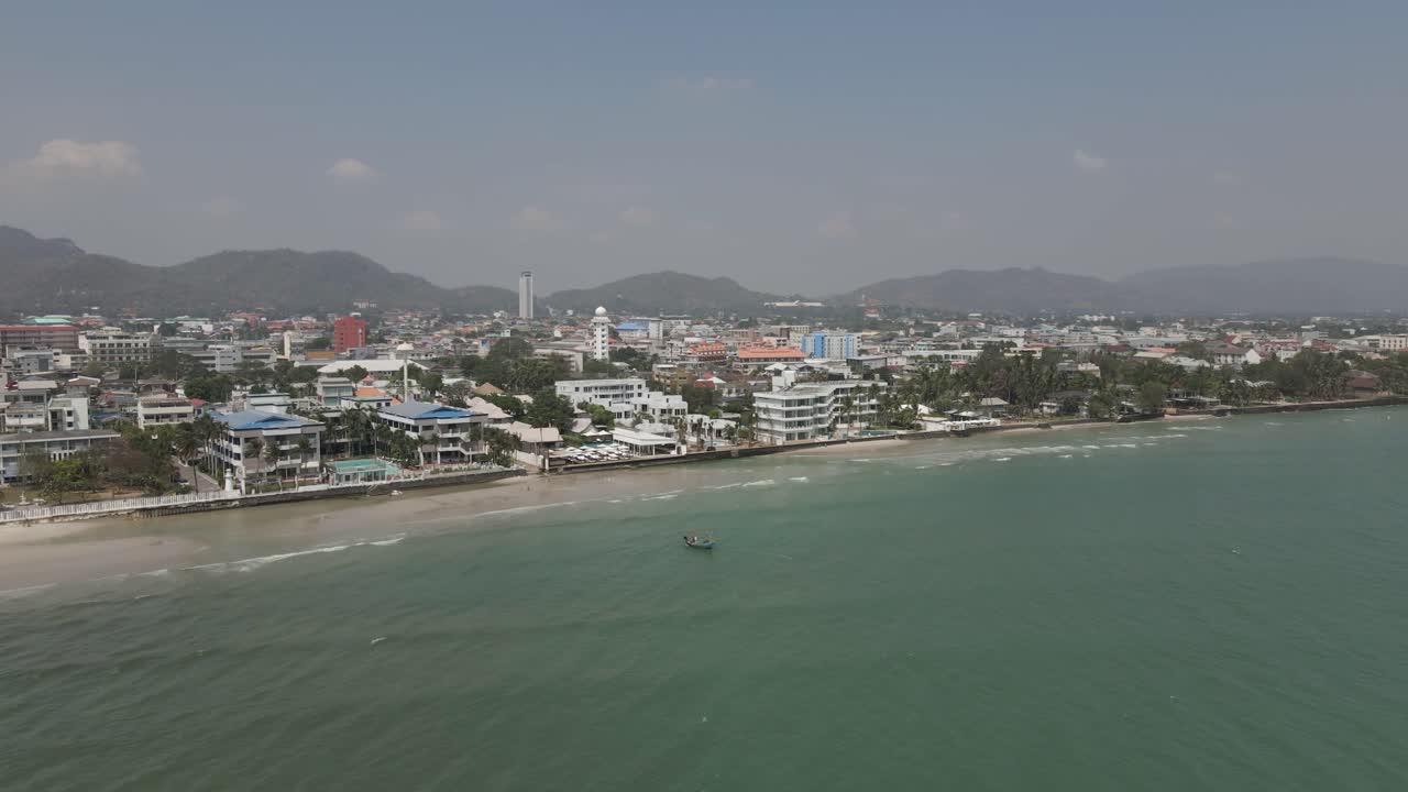 Flyover shallow beach to Hua Hin cityscape skyline in coastal Thailand