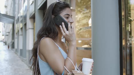 mujer morena hablando por teléfono móvil y viendo