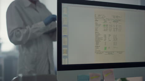 Medicine-worker-typing-patient-information-on-tablet-standing-modern-office.