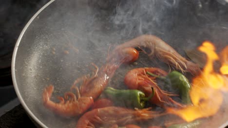 cooking shrimps in frying pan with flame