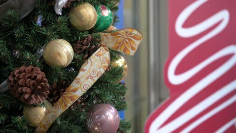 Weihnachtliche-Trockene-Tannenzapfen-Und-Goldkugeln-Ornamente-Hängen-An-Einer-Geschmückten-Weihnachtskiefer