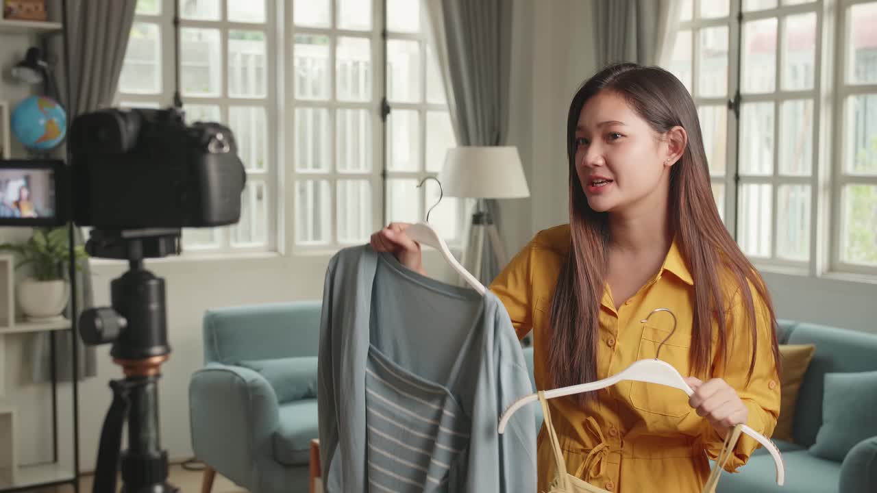 Fashion blogger asiatica che mostra camicie casual colorate in video