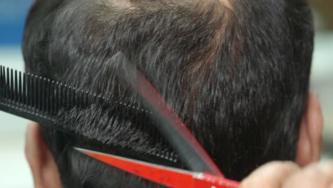un hombre se corta el cabello en una barbería.