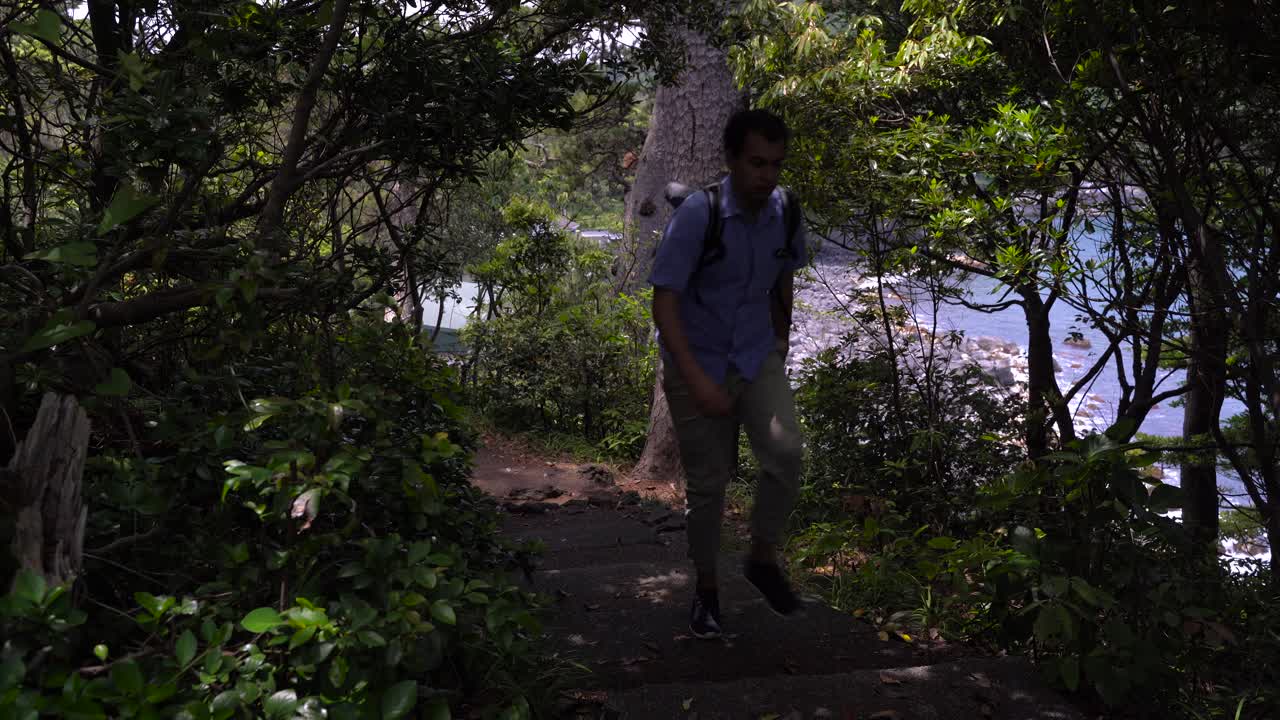 일본의 아름다운 바다 옆 숲에서 하이킹하는 남자