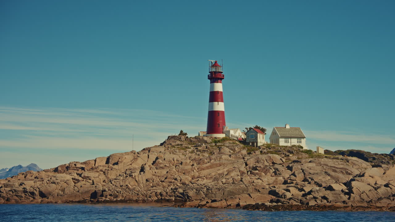 Boat tour around the small fishing islands of the Lofoten, Norway. View of a small lighthouse from the sea.