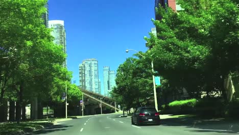 Breiter-Sonniger-Schuss,-Der-Durch-Die-Windschutzscheibe-Des-Autos-Nach-Vorne-Schaut,-Während-Das-Fahrzeug-Die-Kreuzung-Löscht-Und-Auf-Der-Lakeshore-Avenue-In-Toronto-Nach-Osten-Fährt