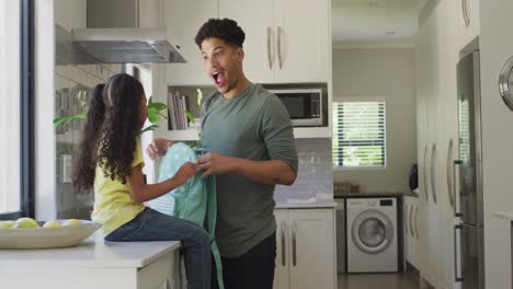 Happy-biracial-father-and-daughter-packing-lunch-for-school