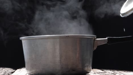 white smoke and steam effect from hot pot over black background.