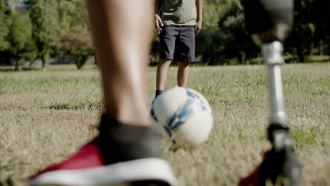primer plano de la pierna artificial del hombre pateando la pelota