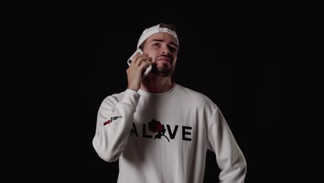 hombre de moda de los años 20 que contesta el teléfono móvil, hablando, ancho, fondo negro