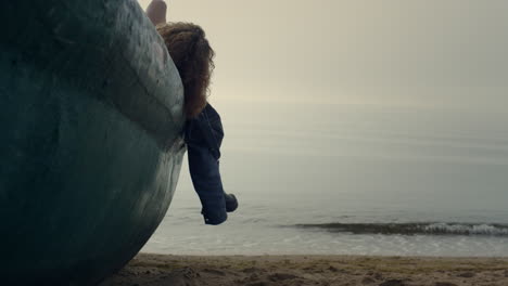 unknown relaxed woman lying old boat on beach. girl relax on beautiful nature.