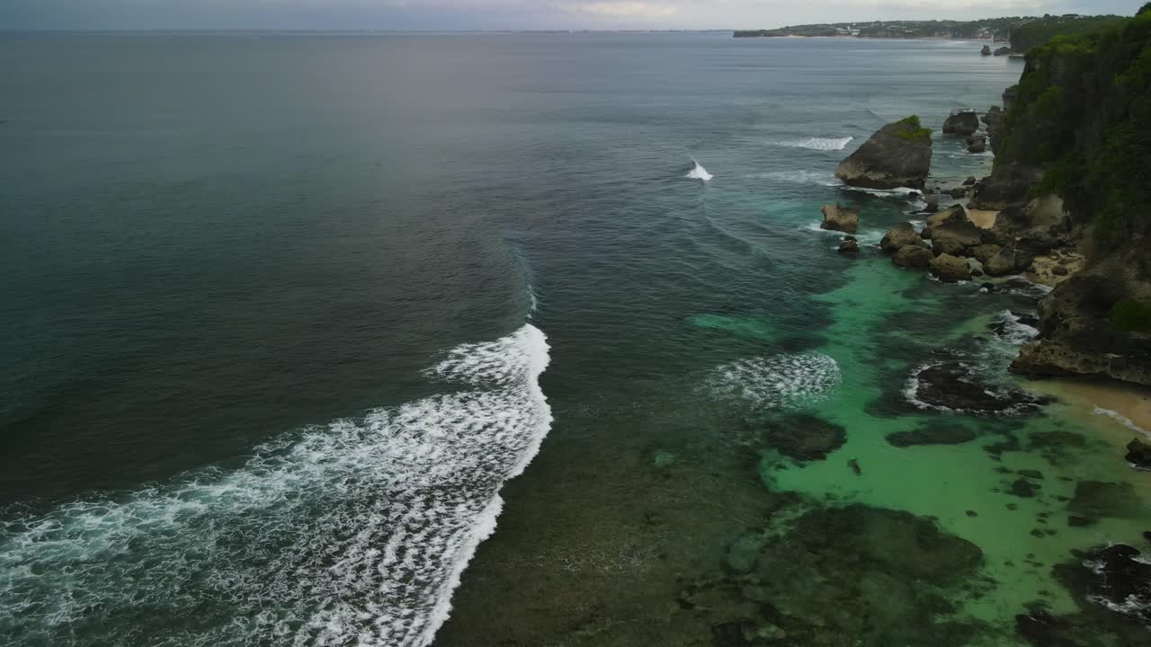 Scogliera, spiaggia e onde dell'oceano a Bali, Indonesia
