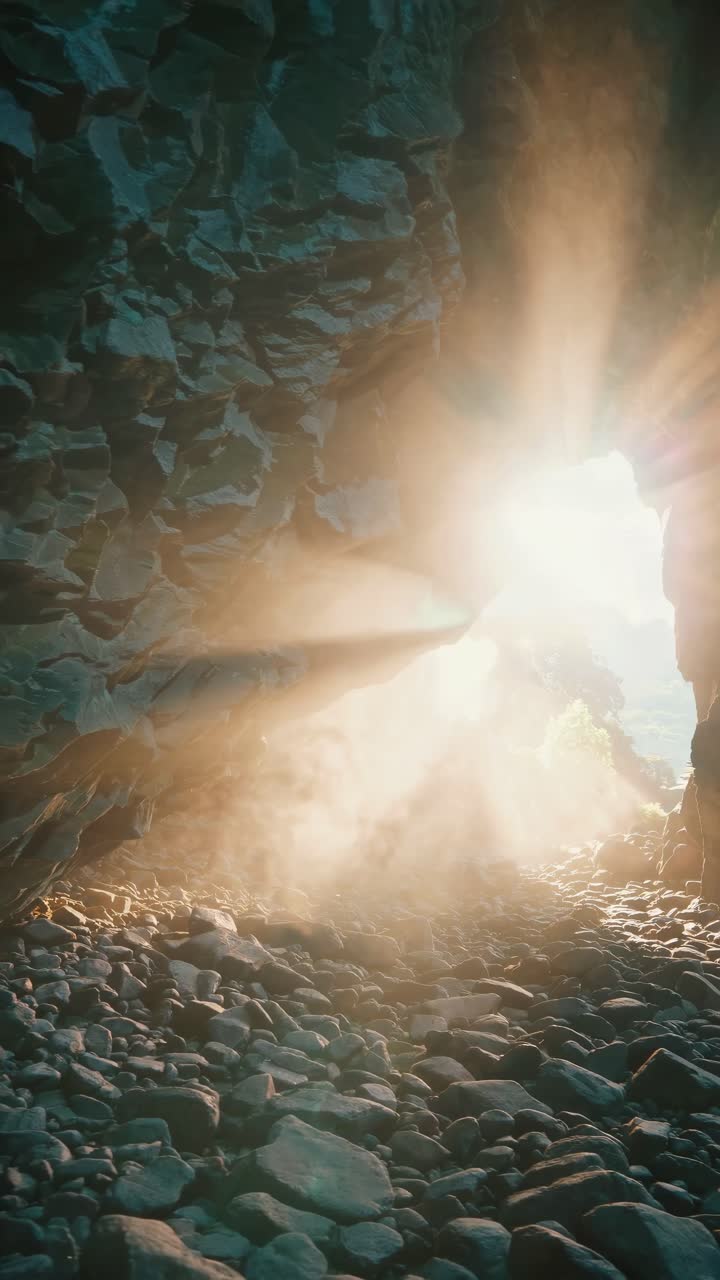 Sunlight streams into a rocky cave, creating a mystical atmosphere