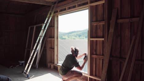 man in protective headphones using electric circular saw - wide