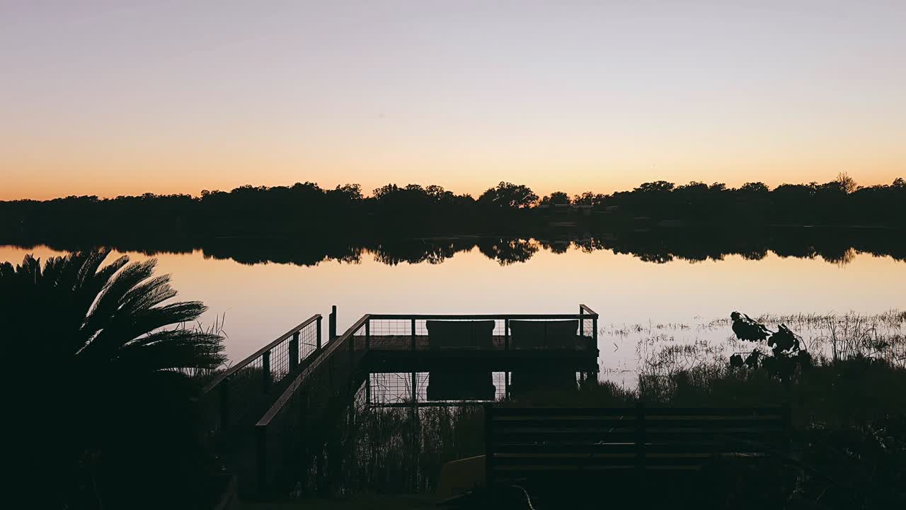 Tramonto su un lago con un molo