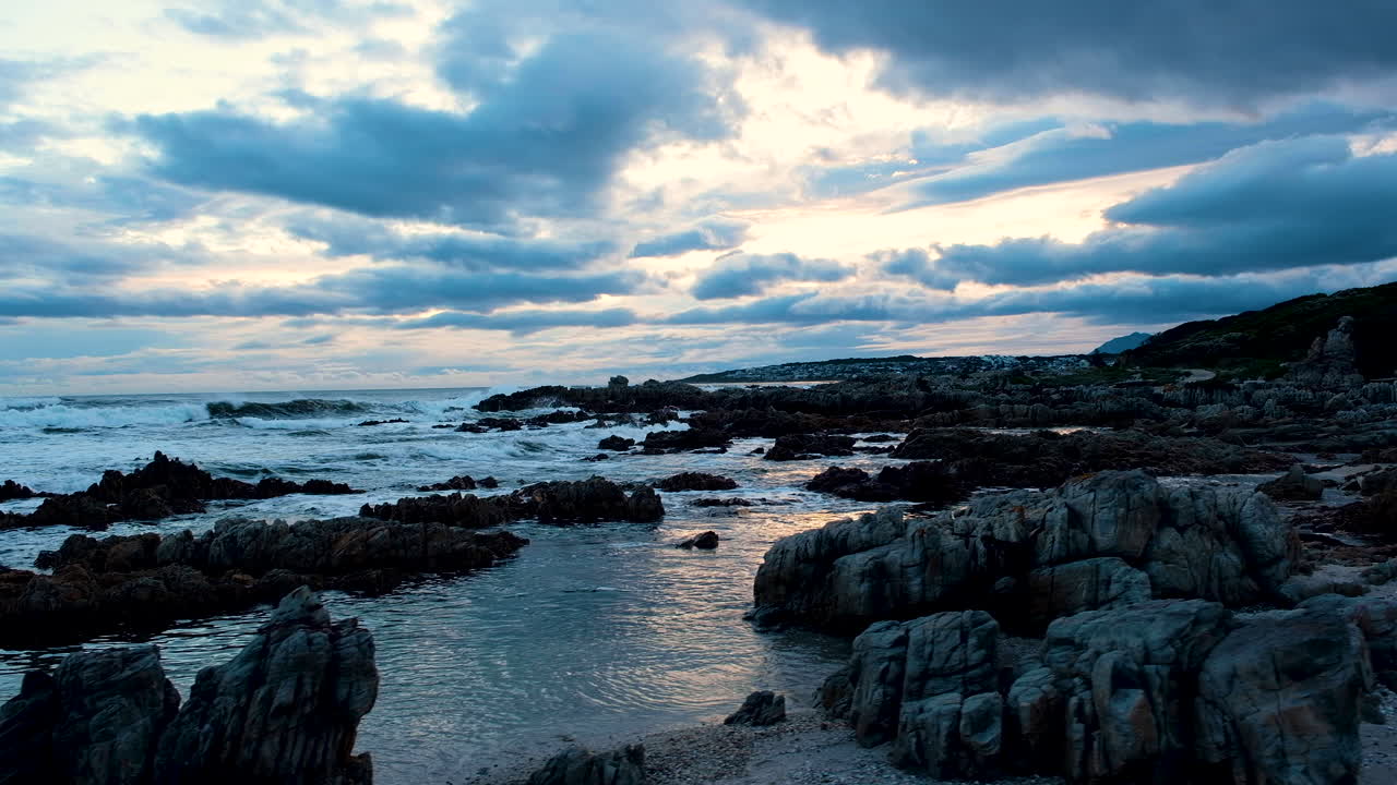 paisaje nuboso de humor vibrante al atardecer sobre la costa rocosa, camiones sobre la playa