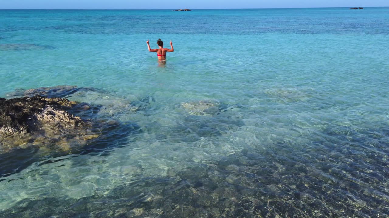 젊고 열정적인 소녀는 춤을 추기 위해 엘라포니시 해변의 청록색 바다에서 혼자 있는 것을 이용합니다
