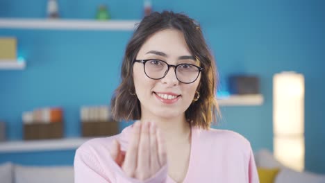 happy and beautiful young woman calling invites with her hand.