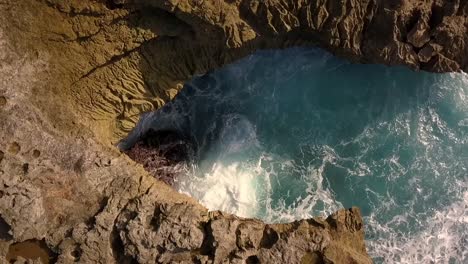 audaz vista aérea vuelo lentamente 360 círculo drone disparó grandes olas del océano estrellándose en las rocas de la lágrima del diablo en lembongan