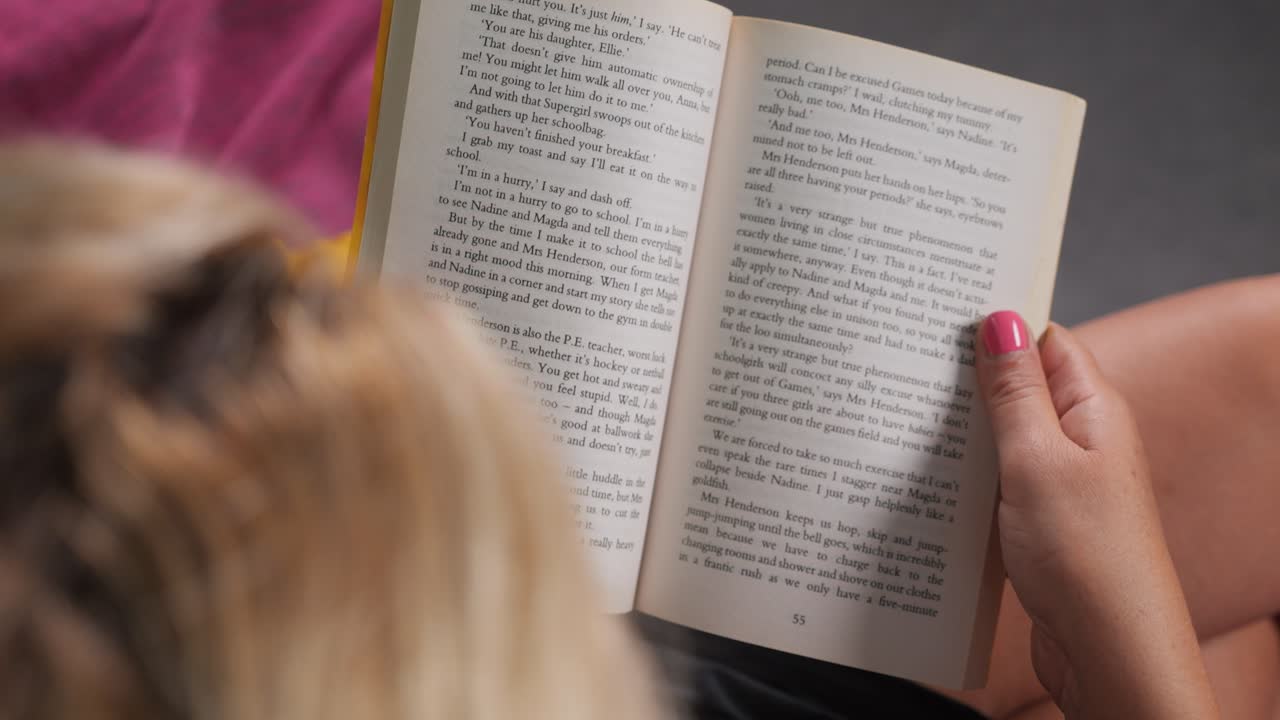 punto de vista de la lectura de una novela, por encima del hombro vista de la mujer volviendo páginas