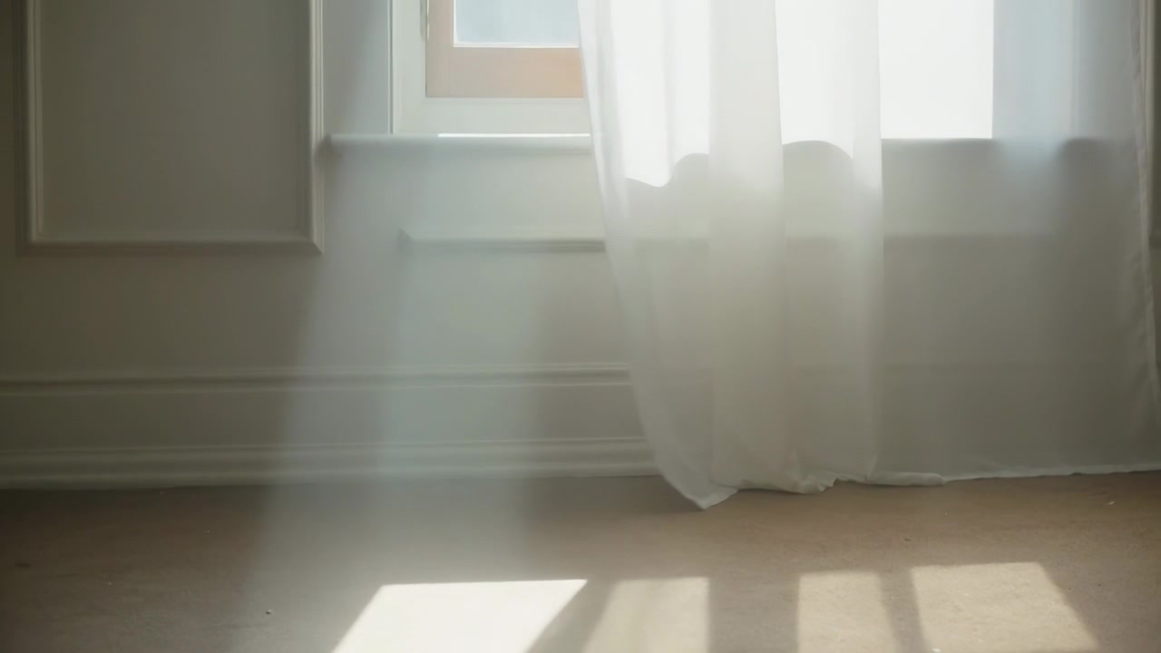 Tenda bianca trasparente e telaio della finestra che si spostano, esponendo la finestra nella stanza, con una corrente d'aria che ammorbidisce le macchie di sole.