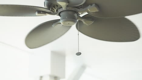 Retro-ceiling-fan-spinning-in-slow-motion-daytime-natural-light