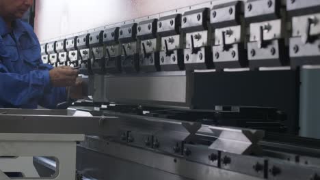 a worker repairs a modern hydraulic bending machine at a metallurgical plant