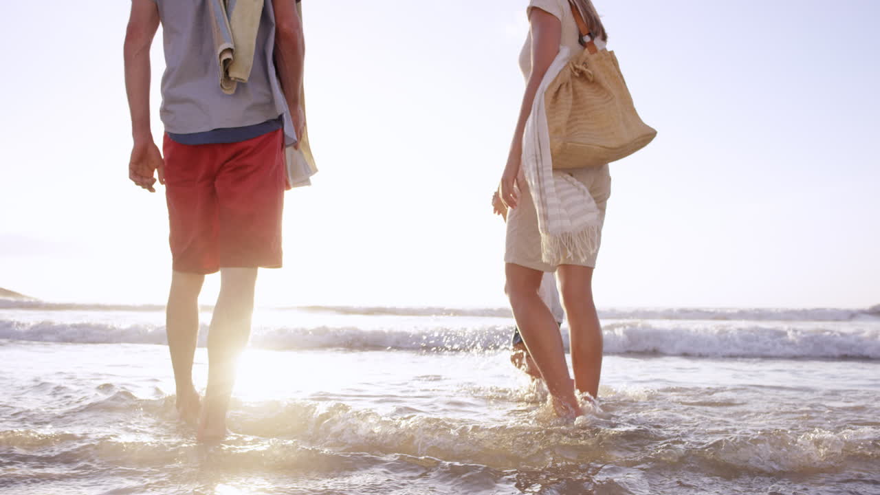 행복 한 가족 이 휴가 에 있는 해 가 지는 해변 에서 파도 에서 놀고 있다