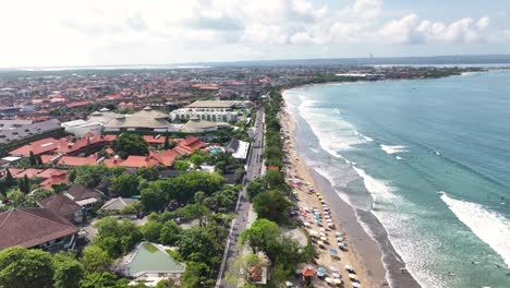 kuta beach in bali, indonesia. drone view of sandy beach with umbrellas and people on holiday.