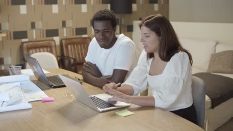 diverse young startup managers sitting at table with laptops