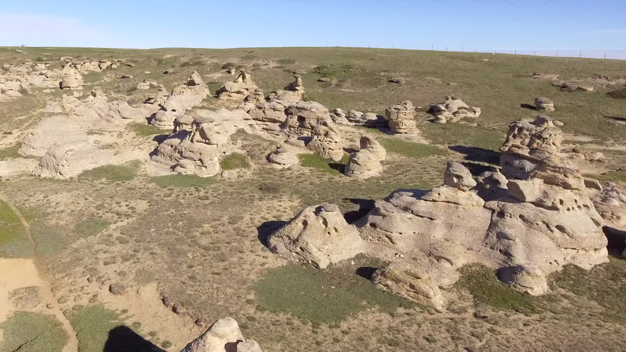 Unique shapes of natural erosion sculpture, hoodoos on green prairie