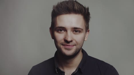 handsome smiling young man. portrait of handsome man in a studio on a gray background