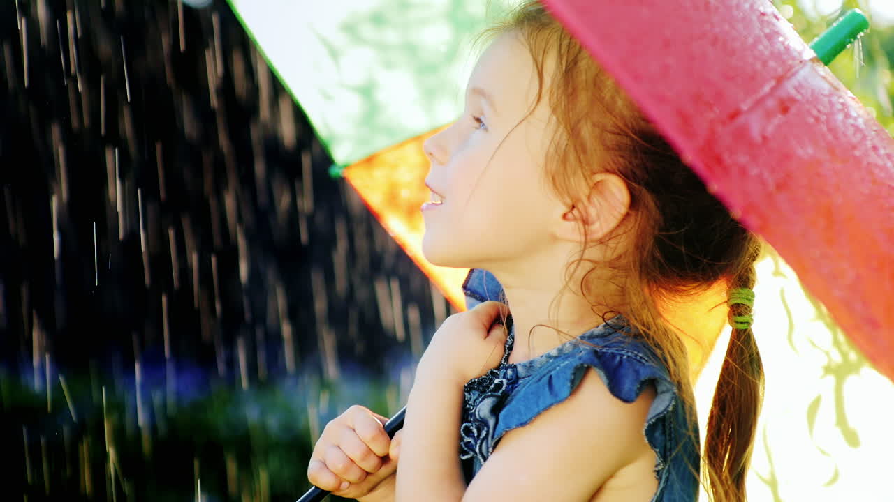 ra의 우산 아래 있어야 하는 비를 즐기는 평온한 소녀의 프로필 초상화