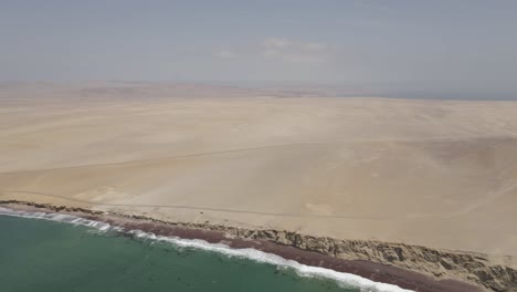 in paracas national reserve, pacific ocean meets endless desert sand