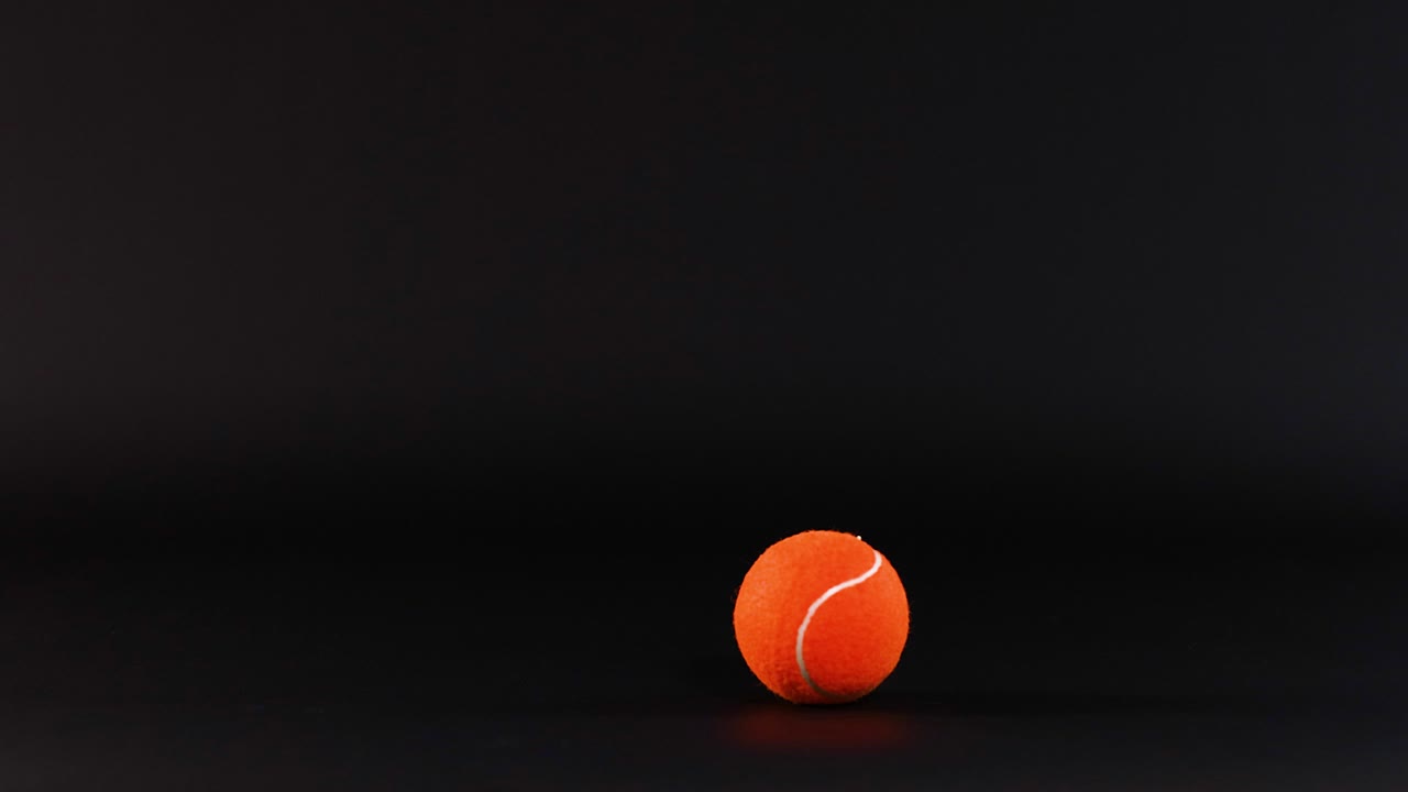 bola de tenis moviéndose a través de un fondo oscuro