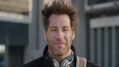 close-up-portrait-attractive-young-man-smiling-enjoying-successful-urban-lifestyle-happy-businessman-looking-cheerful-in-city-at-sunset-slow-motion