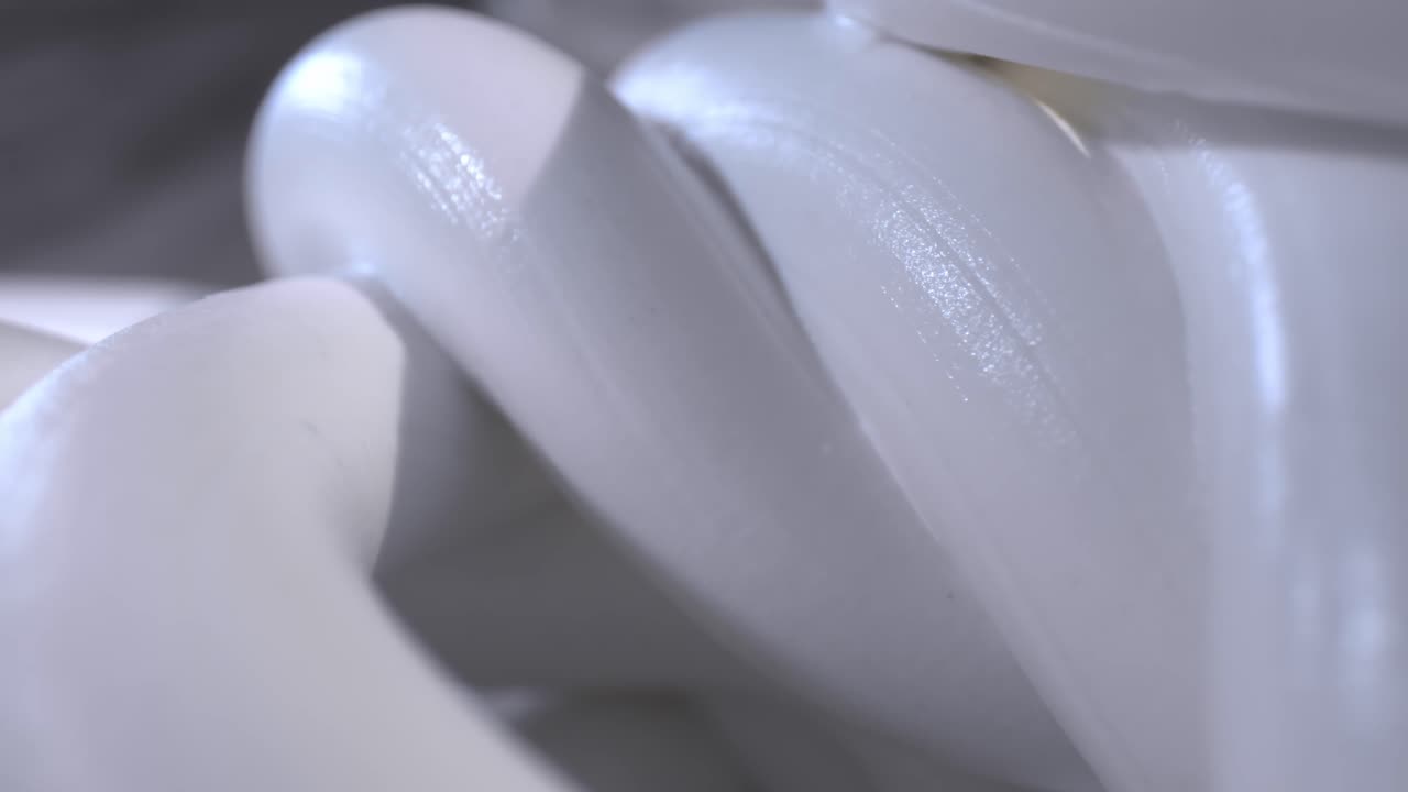 천천히 오른쪽으로 이동, 카메라를 향해 흐르는 흰색 물질 가닥의 자세한 매크로 보기