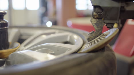 Side-view-of-bead-breaker-separating-tyre-from-rim,-shallow-depth-closeup