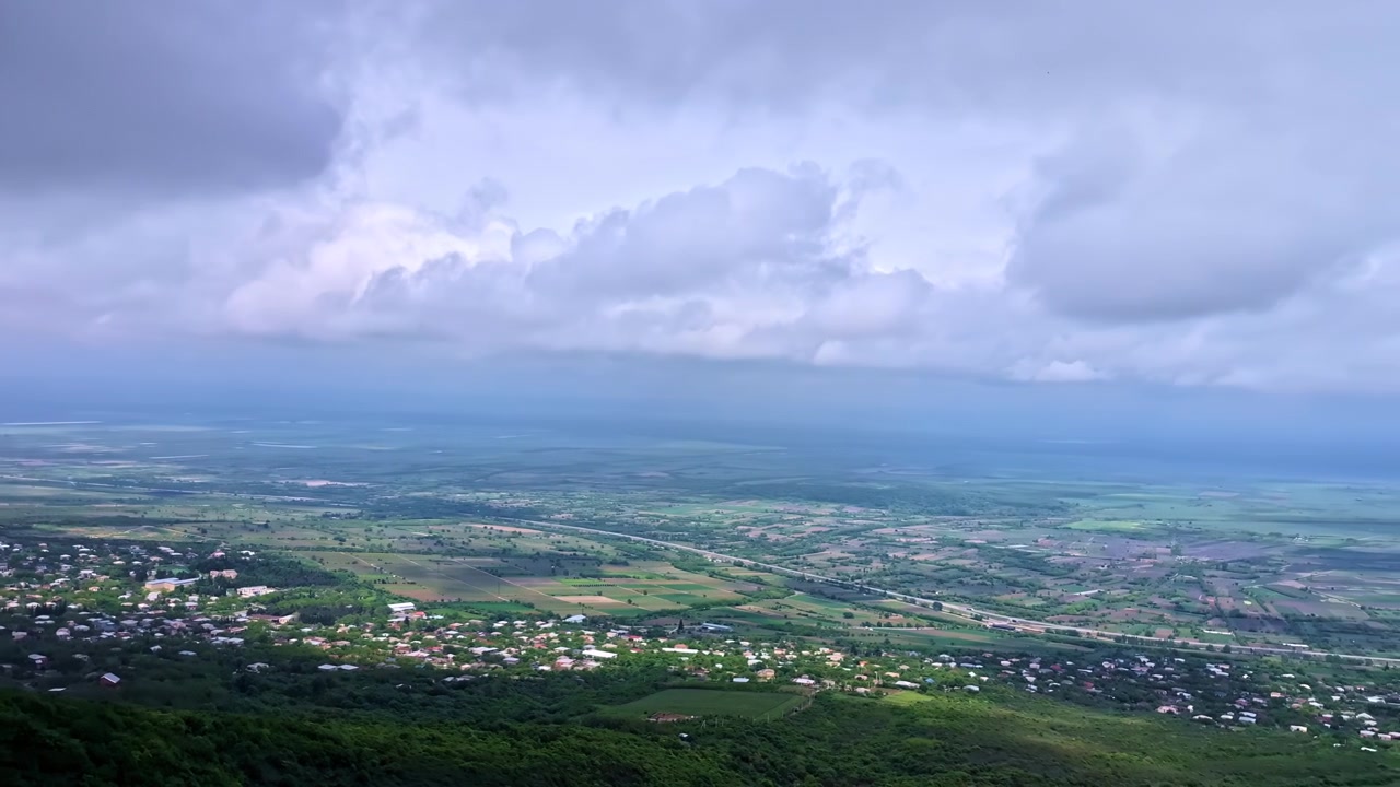 Toàn cảnh từ trên cao một thị trấn nông thôn và thung lũng xanh tươi dưới bầu trời đầy mây ấn tượng
