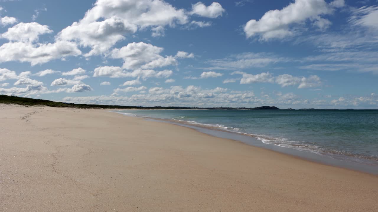 Spiaggia di Huskisson, nel cuore di Jervis Bay in Australia, deserta in una giornata di sole e nuvole, ripresa fissa.