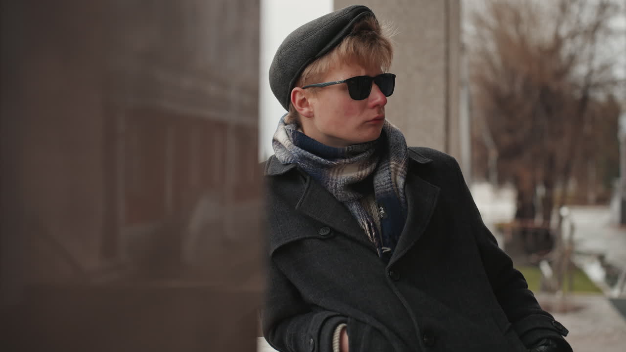 Scena urbana con elementi di moda. Un vivace angolo di città presenta un individuo alla moda con accessori, in un ambiente urbano dinamico che mostra una persona chic che indossa occhiali da sole e una sciarpa elegante.