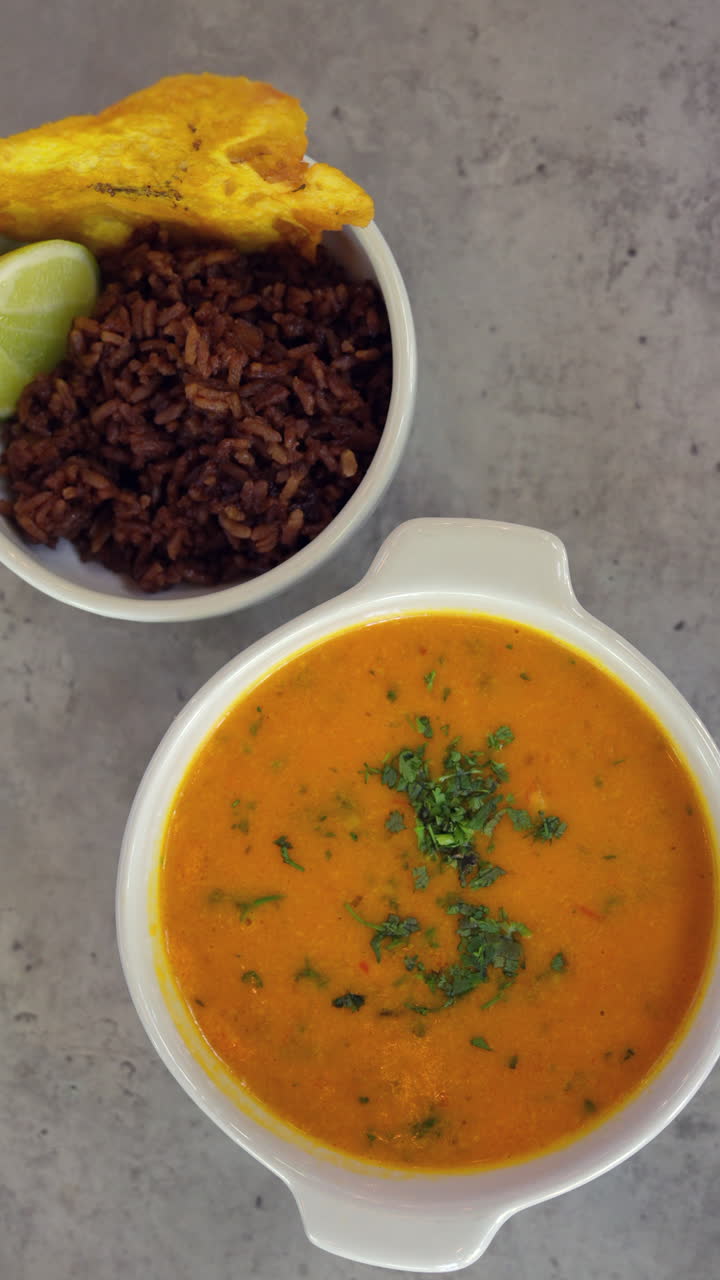 Savor a rich cazuela de camarones with vibrant herbs, captured as a vertical video for mobile, perfect for social media stories and food enthusiasts. A tantalizing taste of Colombia