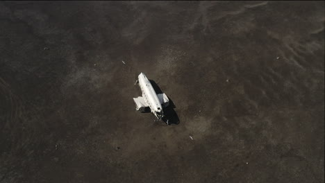 una toma de avión no tripulado de un avión estrellado, rodeado de gaviotas en el medio de la nada, con ondas de calor