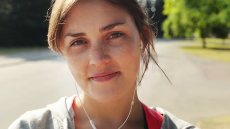 Retrato-De-Mujer-Bonita-Sonriendo-Usando-Auriculares-Al-Aire-Libre