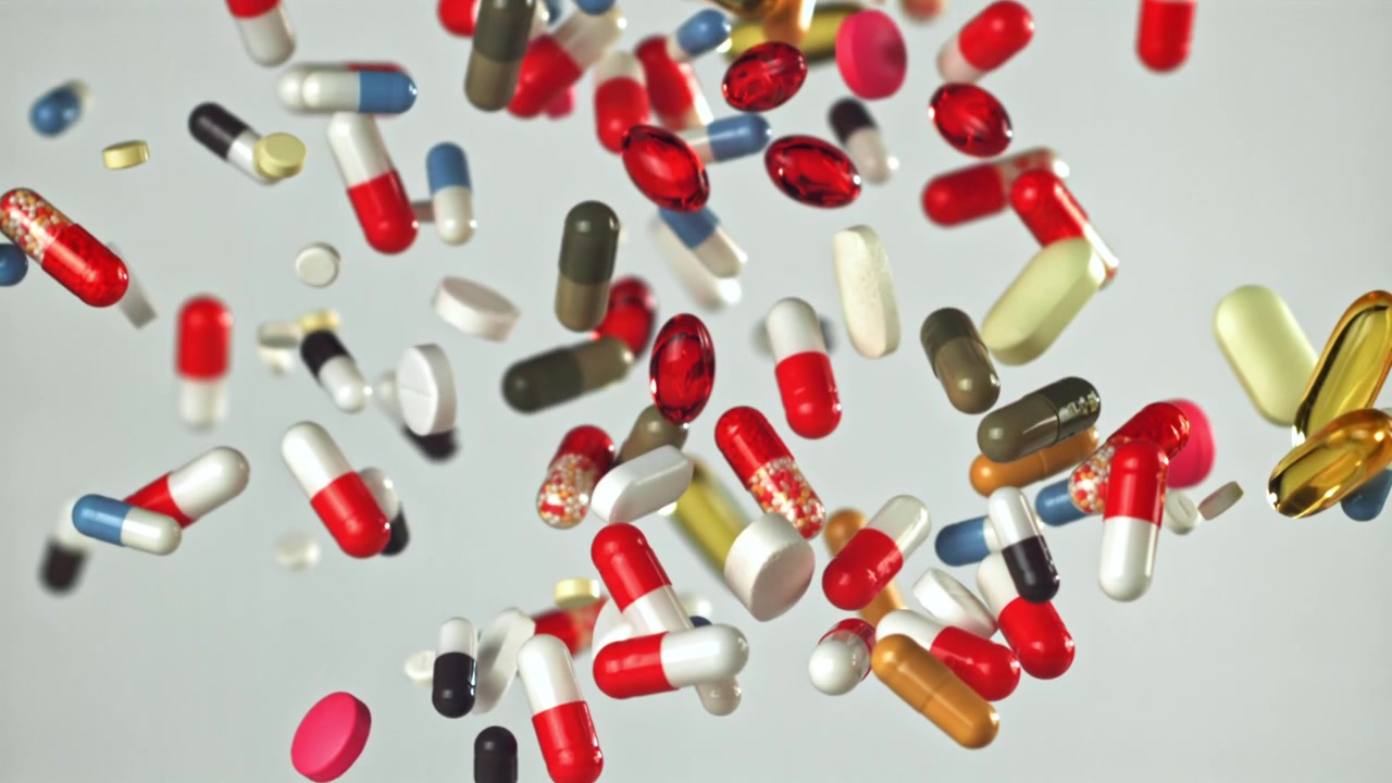 Many Colorful Pills and Capsules Falling in Slow Motion